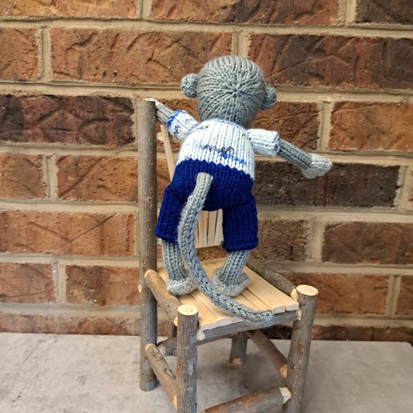 Handknit Monkey Toy - light gray with blue shorts and a white and blue speckled shirt