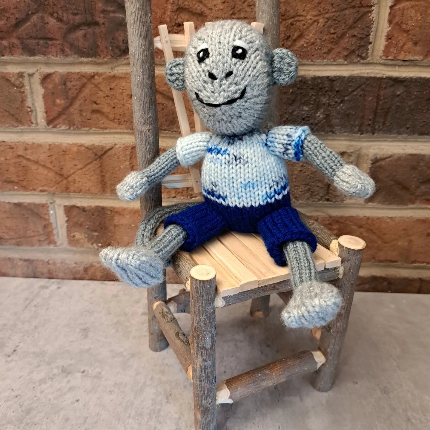 Handknit Monkey Toy - light gray with blue shorts and a white and blue speckled shirt